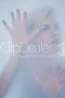 Blonde woman touching frosted glass