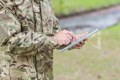 Soldier looking at tablet pc in park