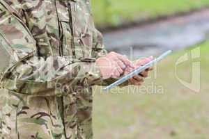 Soldier looking at tablet pc in park