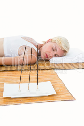 Attractive blonde woman resting on bamboo mat