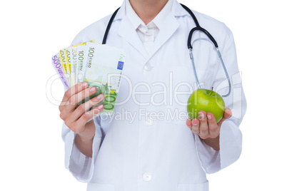 Doctor holding cash and green apple
