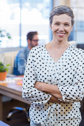 Smiling woman standing arms crossed with her partner behind