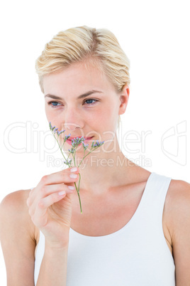 Gorgeous blonde woman smelling dried flower