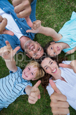 Happy family in the park together thumbs up