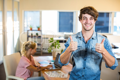 Smiling businessman posing with his partner behind him