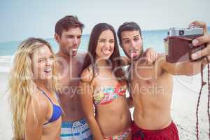 group of friends in swimsuits taking a selfie