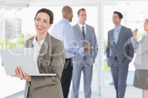 Businesswoman with his laptop and her colleagues behind