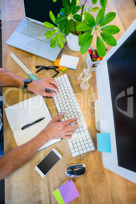 Man working at his desk and typing on keyboard