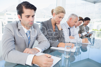 Business team taking notes during conference