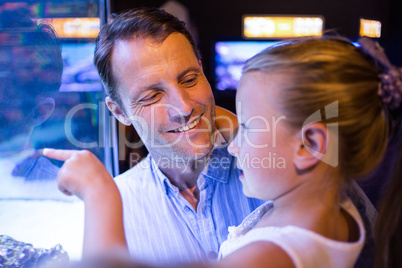 Daughter lookingand father looking at fish in tank