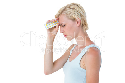 Attractive woman having headache and holding pack of pills