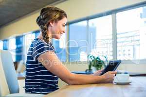 Smiling brunette holding tablet