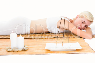 Attractive blonde woman resting on bamboo mat