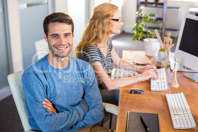 Smiling partners sitting together at desk