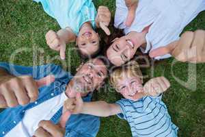 Happy family in the park together thumbs up