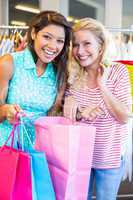Smiling friends holding shopping bags