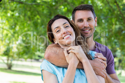 Happy couple smiling at camera in park