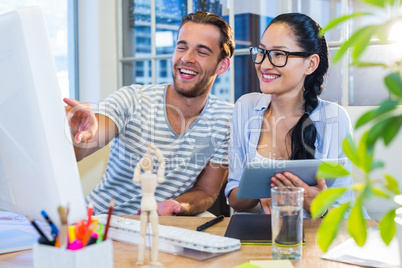 Smiling partners working together on tablet and computer