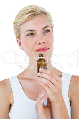 Gorgeous blonde woman smelling bottle of medicine