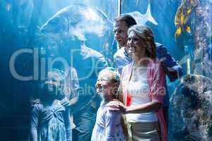 Happy family looking at fish in a tank
