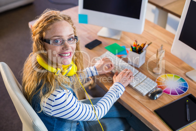 Smiling designer typing on keyboard