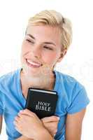Pretty smiling blonde woman holding bible