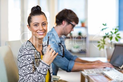 Smiling businesswoman posing with her partner behind