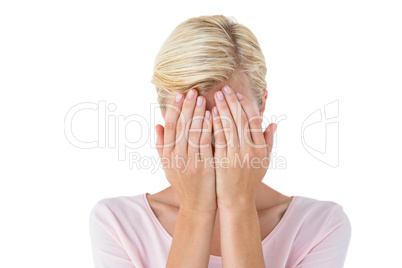Blonde woman covering her face
