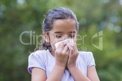 Little girl blowing his nose