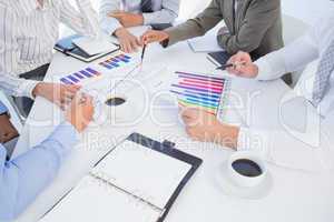 Business team analyzing bar chart graphs