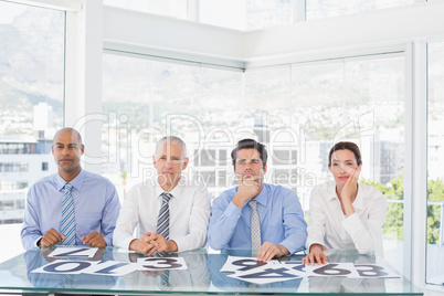 Concentrated business team sitting with their vote on the desk