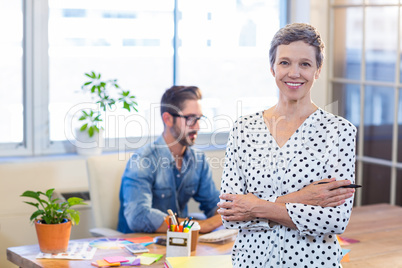 Smiling woman standing arms crossed with her partner behind