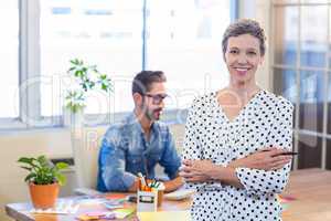 Smiling woman standing arms crossed with her partner behind