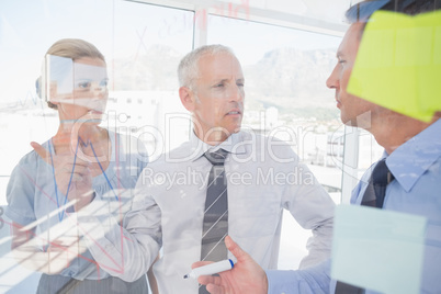 Businessman drawing graph on the glass
