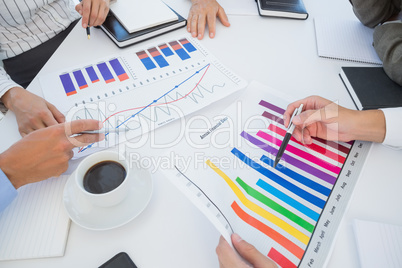 Business team analyzing bar chart graphs