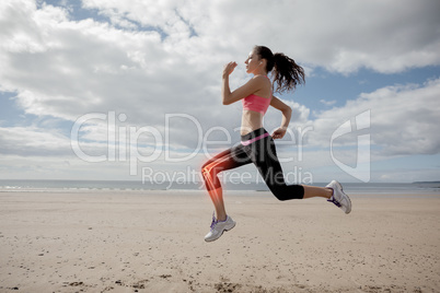 Highlighted leg bones of jogging woman on beach