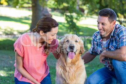 Happy couple with their dog in the park