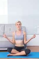 Fit blonde woman meditating