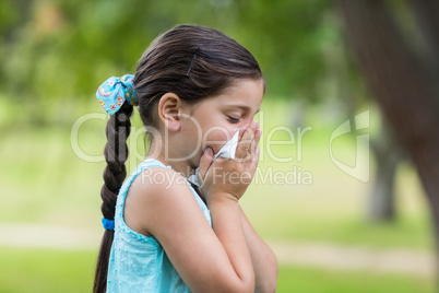 Little girl blowing his nose