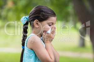 Little girl blowing his nose