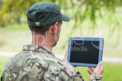 Soldier looking at tablet pc in park