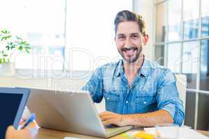 Partners working at desk using laptop and tablet