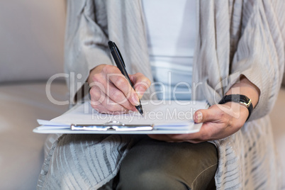 Psychologist sitting on the couch and taking notes