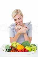 Happy blonde woman sitting above healthy food