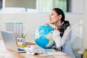 Pretty businesswoman holding globe
