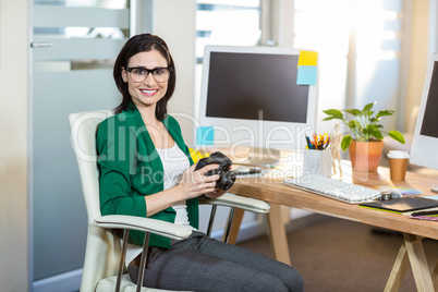 Smiling brunette holding digital camera