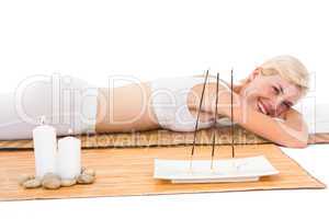Attractive blonde woman resting on bamboo mat