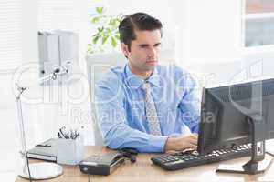 Concentrated businessman typing on the keyboard