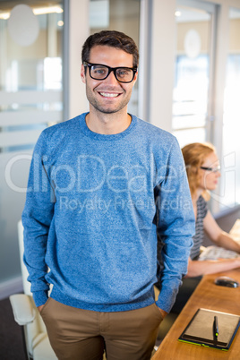 Smiling businessman posing with his partner behind him