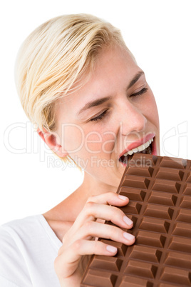 Attractive woman eating big bar of chocolate